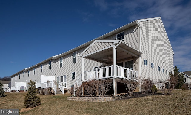 rear view of property with a yard and ceiling fan