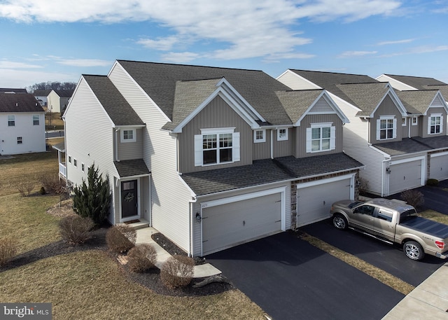 view of front of house with aphalt driveway, a garage, a residential view, and a shingled roof