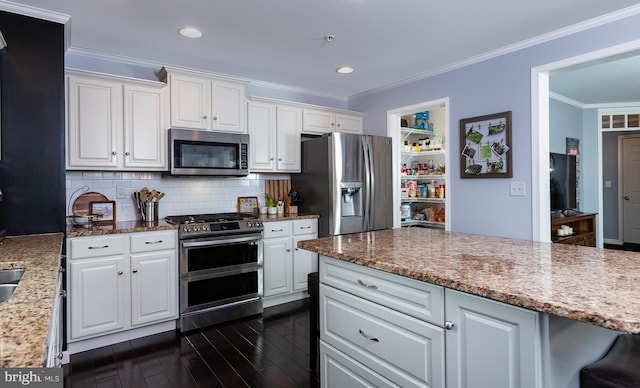 kitchen featuring stainless steel appliances, decorative backsplash, dark wood-type flooring, white cabinets, and crown molding