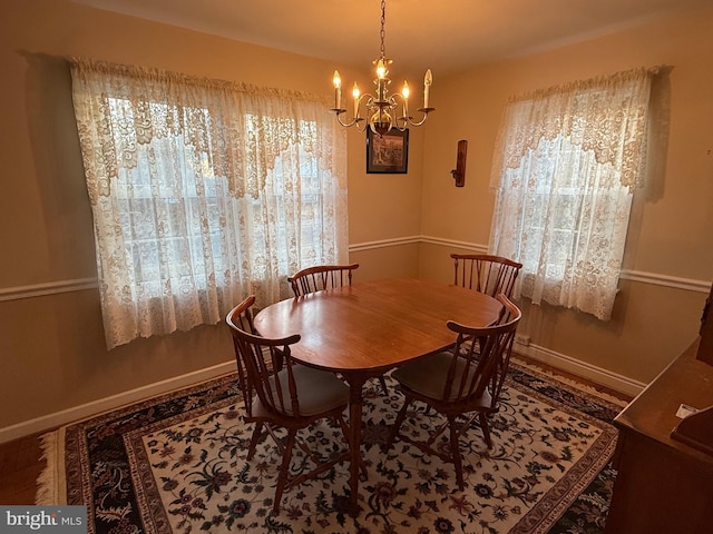 dining room featuring an inviting chandelier and baseboards