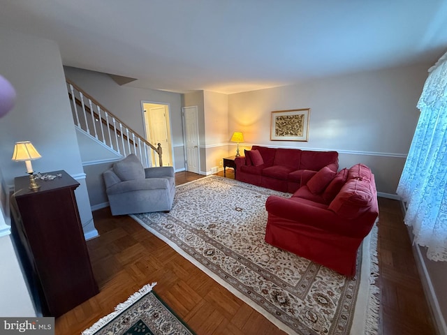 living room featuring stairway and baseboards