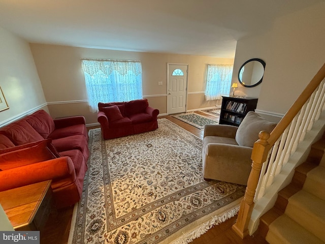 living room with baseboards, a healthy amount of sunlight, and stairs