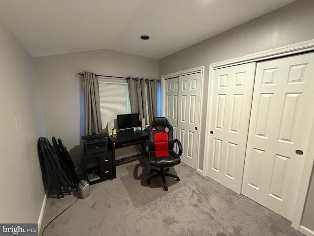 office space with baseboards, lofted ceiling, and carpet flooring