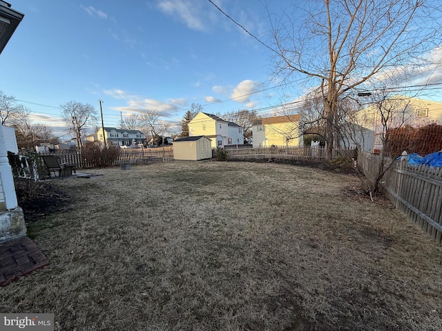 view of yard with an outbuilding, a shed, and a fenced backyard