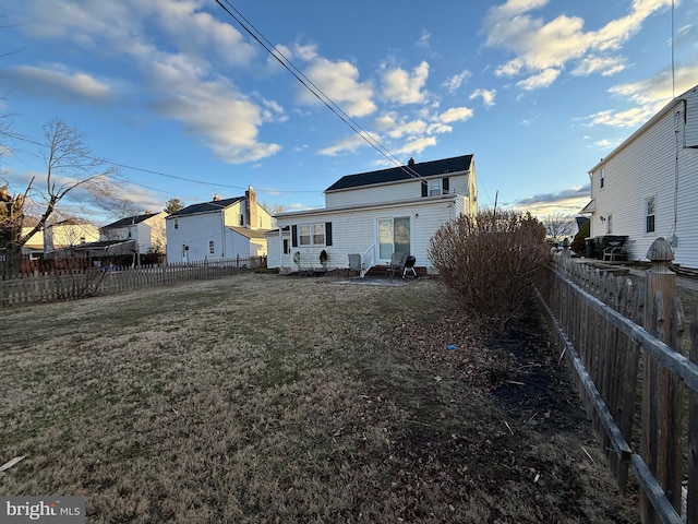 back of property with a lawn and a fenced backyard