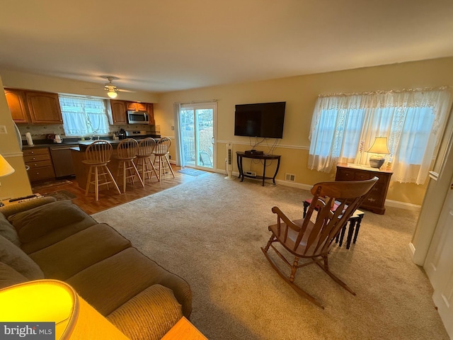 living area featuring visible vents, plenty of natural light, and baseboards