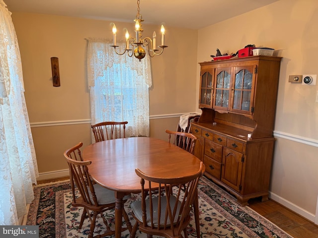 dining area featuring baseboards and a chandelier