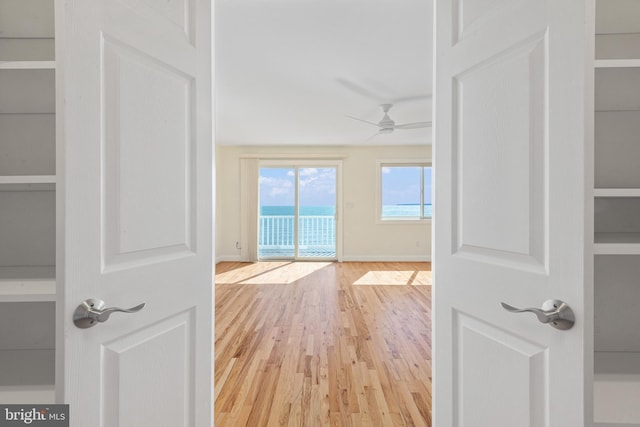 hallway featuring wood finished floors and baseboards