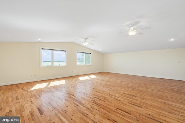 empty room featuring light wood finished floors, ceiling fan, baseboards, and vaulted ceiling