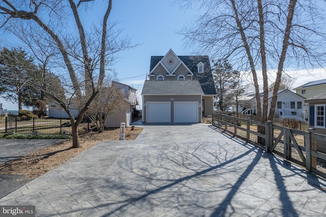 view of property exterior featuring aphalt driveway, an outdoor structure, fence, and a shingled roof