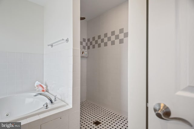 full bath featuring a garden tub and a tile shower