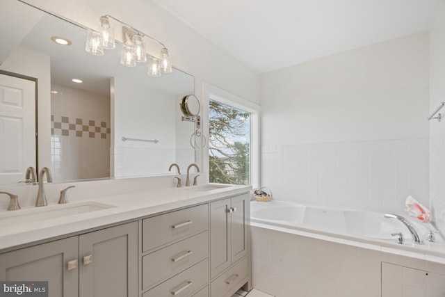 full bath with recessed lighting, double vanity, a sink, and a bath