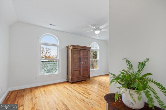 entryway featuring ceiling fan, lofted ceiling, visible vents, baseboards, and light wood finished floors