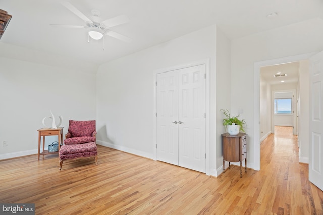 sitting room with ceiling fan, light wood finished floors, and baseboards