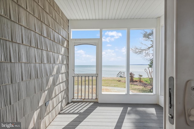 unfurnished sunroom featuring a water view