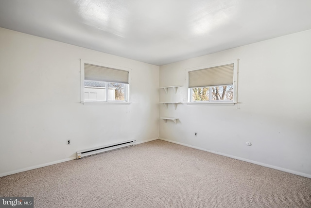 carpeted spare room with a baseboard radiator and baseboards