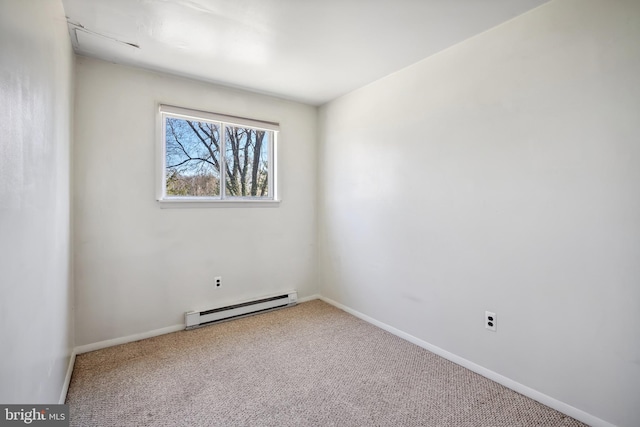 spare room with a baseboard heating unit, carpet floors, and baseboards