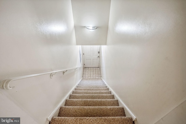 stairs featuring baseboards and carpet floors