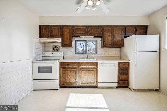 kitchen with ceiling fan, under cabinet range hood, light countertops, white appliances, and a sink