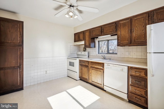 kitchen featuring ceiling fan, under cabinet range hood, light countertops, white appliances, and a sink