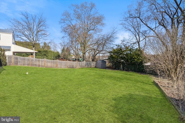 view of yard featuring an outbuilding, fence, and a shed