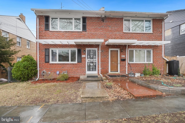 view of property with brick siding and fence