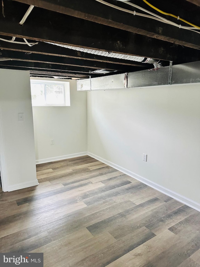 basement with baseboards and wood finished floors