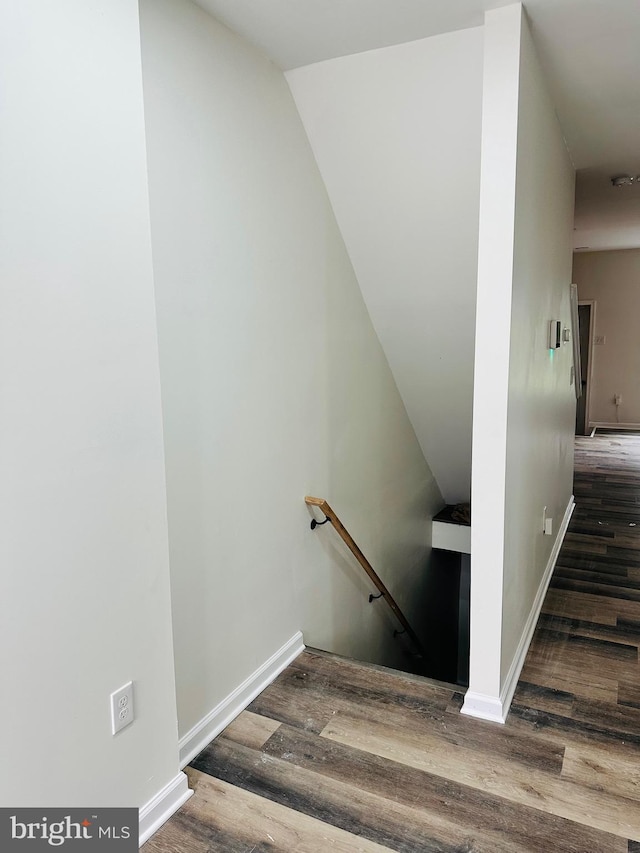 staircase featuring baseboards and wood finished floors