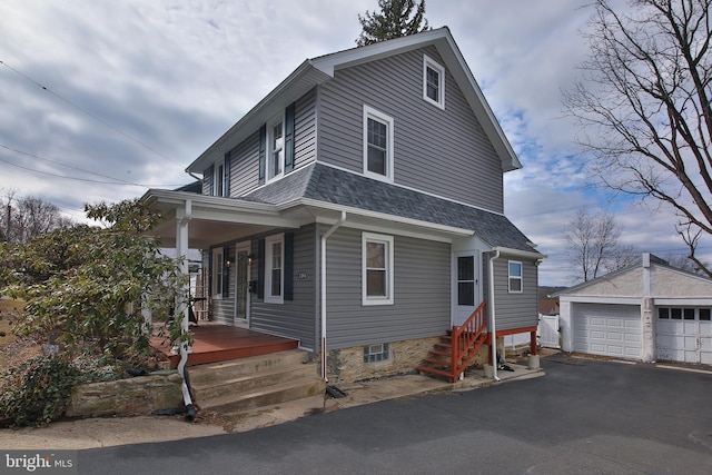 view of front of house featuring roof with shingles, a detached garage, covered porch, entry steps, and an outdoor structure