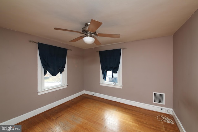 unfurnished room featuring a ceiling fan, baseboards, visible vents, and hardwood / wood-style floors