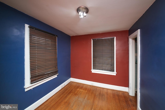 unfurnished room featuring baseboards and wood finished floors