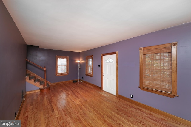 entrance foyer with stairway, wood finished floors, and baseboards