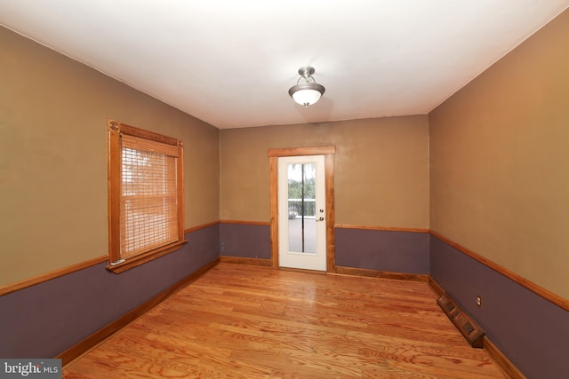 unfurnished room featuring light wood-style floors, baseboards, and visible vents