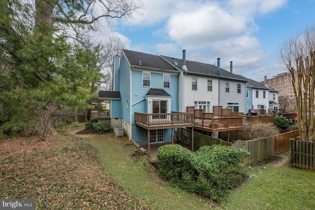 rear view of house with fence, a wooden deck, and central AC unit