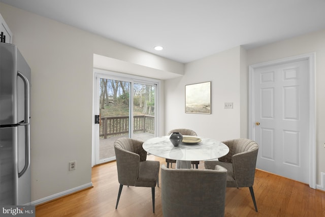 dining room featuring light wood-type flooring, baseboards, and recessed lighting