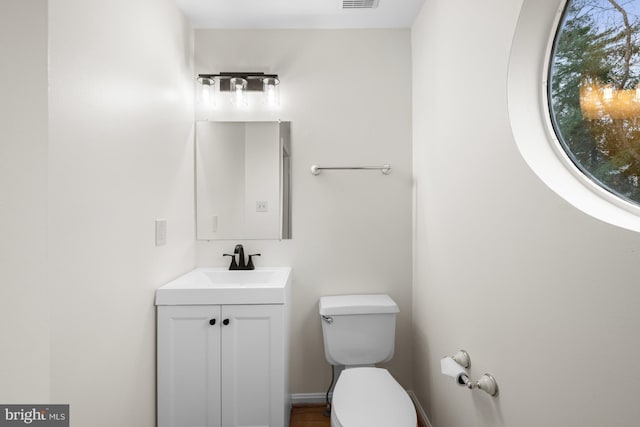 bathroom with visible vents, vanity, and toilet