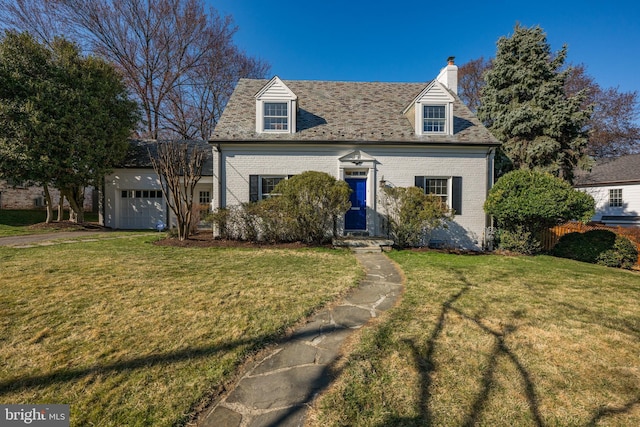 new england style home featuring a front lawn, an attached garage, brick siding, and a chimney