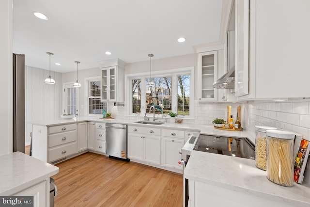 kitchen with stainless steel dishwasher, a peninsula, pendant lighting, and a sink