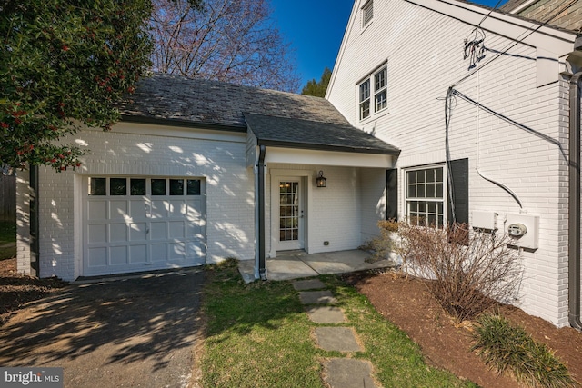 exterior space featuring brick siding and a garage