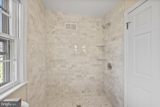 full bathroom featuring visible vents and a tile shower