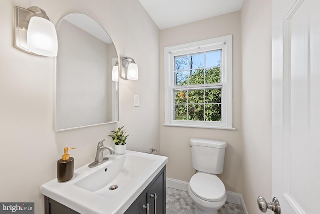 bathroom with toilet, vanity, and baseboards