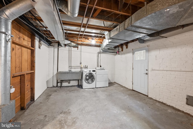 unfinished basement featuring a sink and washing machine and dryer