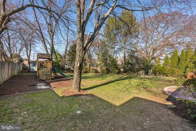 view of yard with fence and a playground