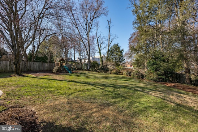 view of yard featuring a playground and fence