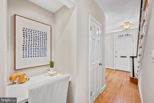 corridor with baseboards and light wood finished floors