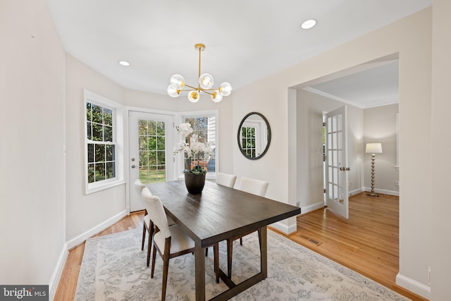 dining room featuring recessed lighting, an inviting chandelier, baseboards, and light wood-style floors