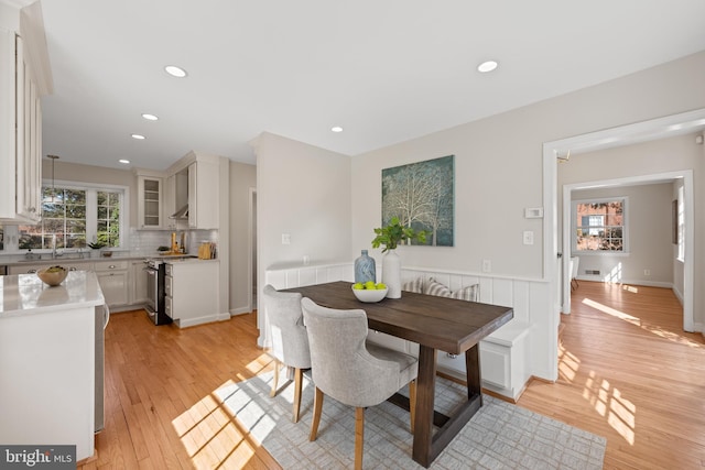 dining room with light wood finished floors and recessed lighting