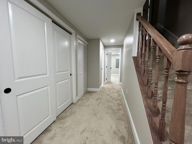 hallway featuring carpet, baseboards, and stairs