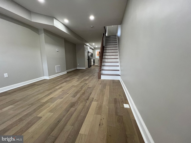 basement with stairway, wood finished floors, visible vents, and baseboards