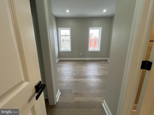 empty room with dark wood-type flooring, recessed lighting, and baseboards